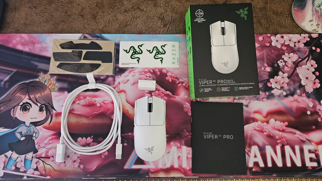 Souris blanche au centre, avec les patins optionnels, câble blanc, récepteur sans fil blanc, autocollants Razer, boîte du Razer Viper V3 Pro, et guide de démarrage rapide.