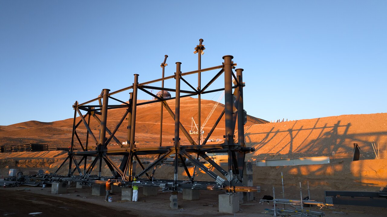 science Sur une colline dans un désert montagneux, de grandes poutres métalliques construisent le cadre d'une grande structure.