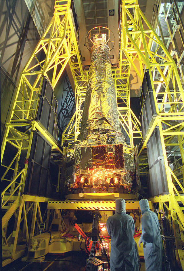 Des techniciens inspectent l'Observatoire X-ray Chandra dans une chambre d'essai avant son lancement en 1999.