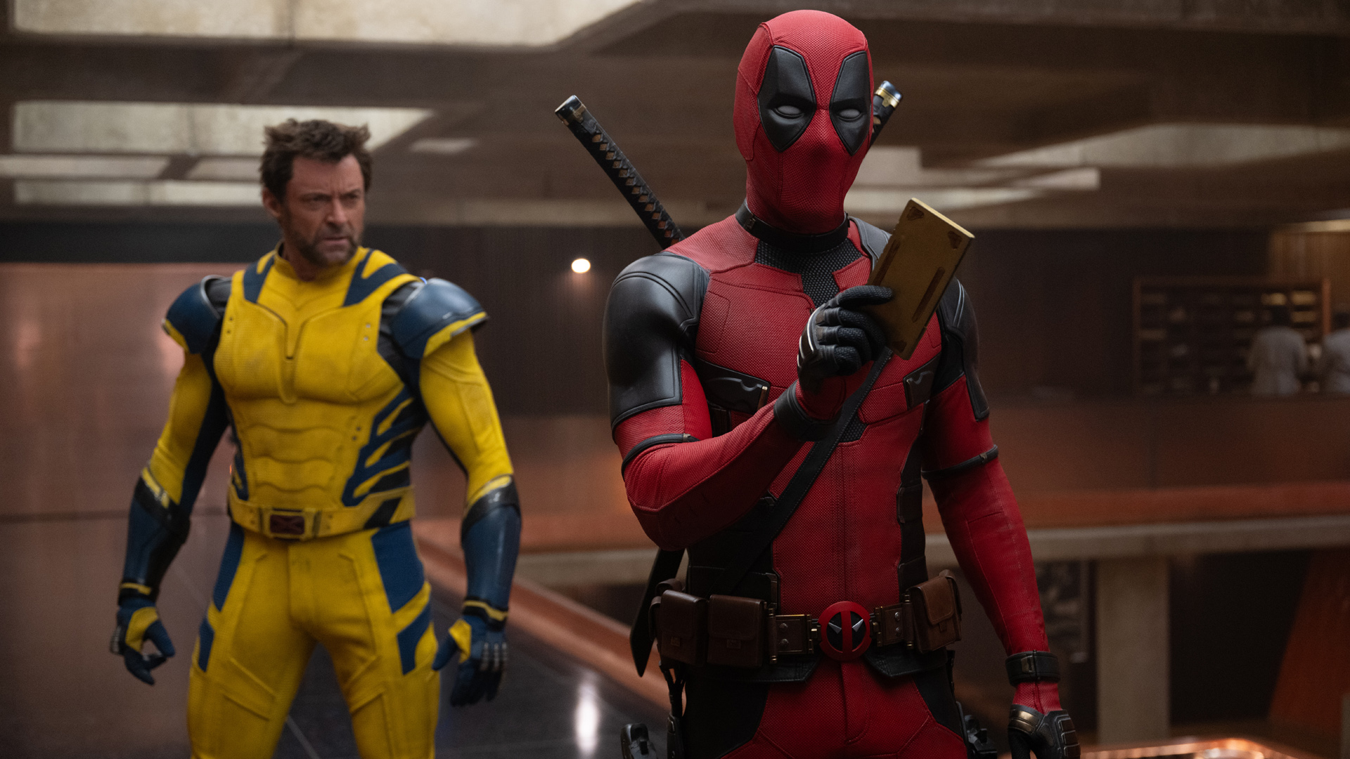 Deadpool tient un appareil TVA pendant que Wolverine observe dans Deadpool 3