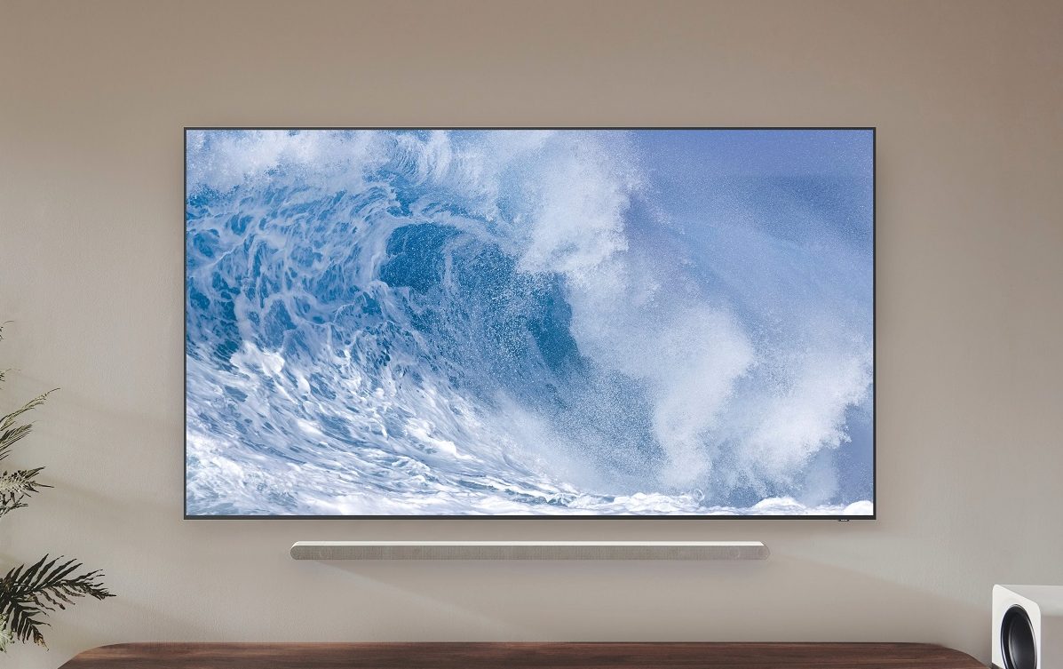 Le téléviseur Samsung QN700B QLED 8K avec une vague sur l'écran, monté au mur.