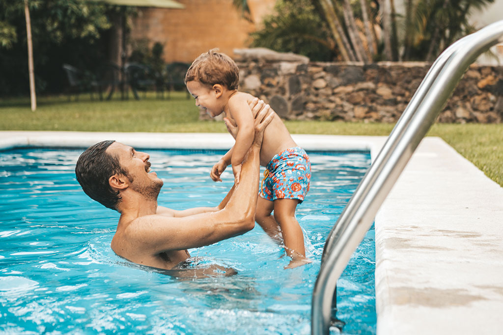 Père et fils jouant dans la piscine