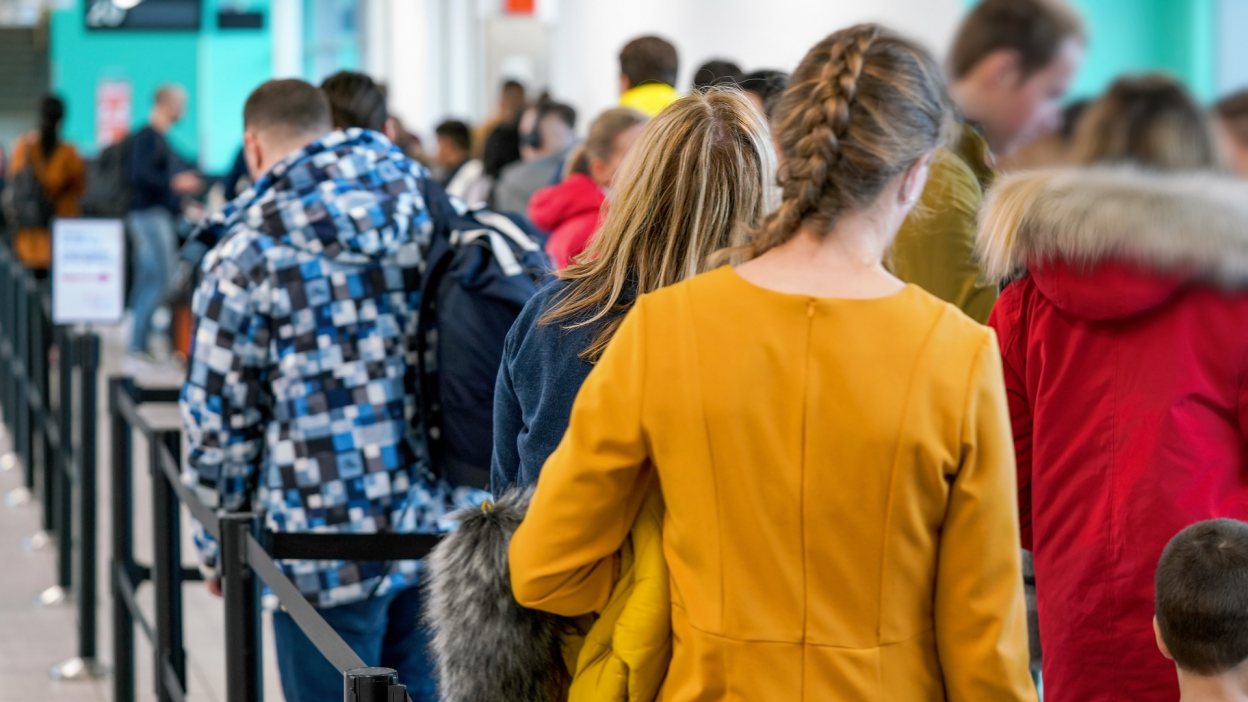 personnes faisant la queue dans un aéroport bondé