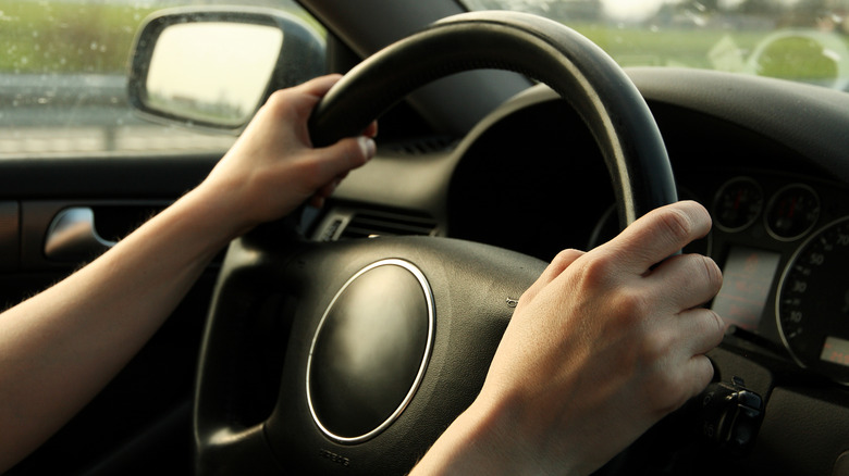 Mains sur le volant d'une voiture