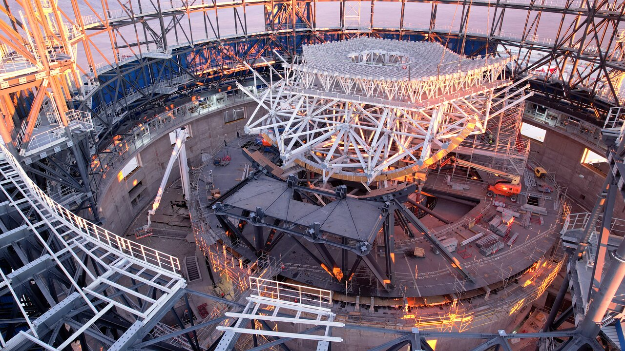 science Vue intérieure d'une grande structure circulaire en construction, remplie de poutres métalliques formant le squelette de la structure.