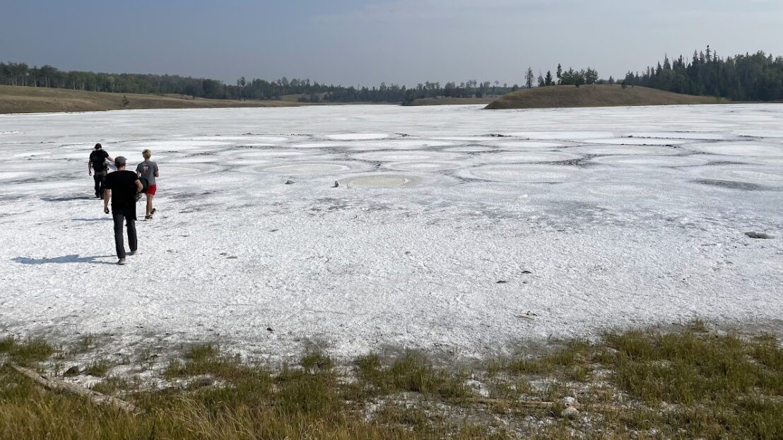 Trois chercheurs marchent sur la croûte salée laissée après l'évaporation de l'eau au lac Last Chance en septembre 2022.