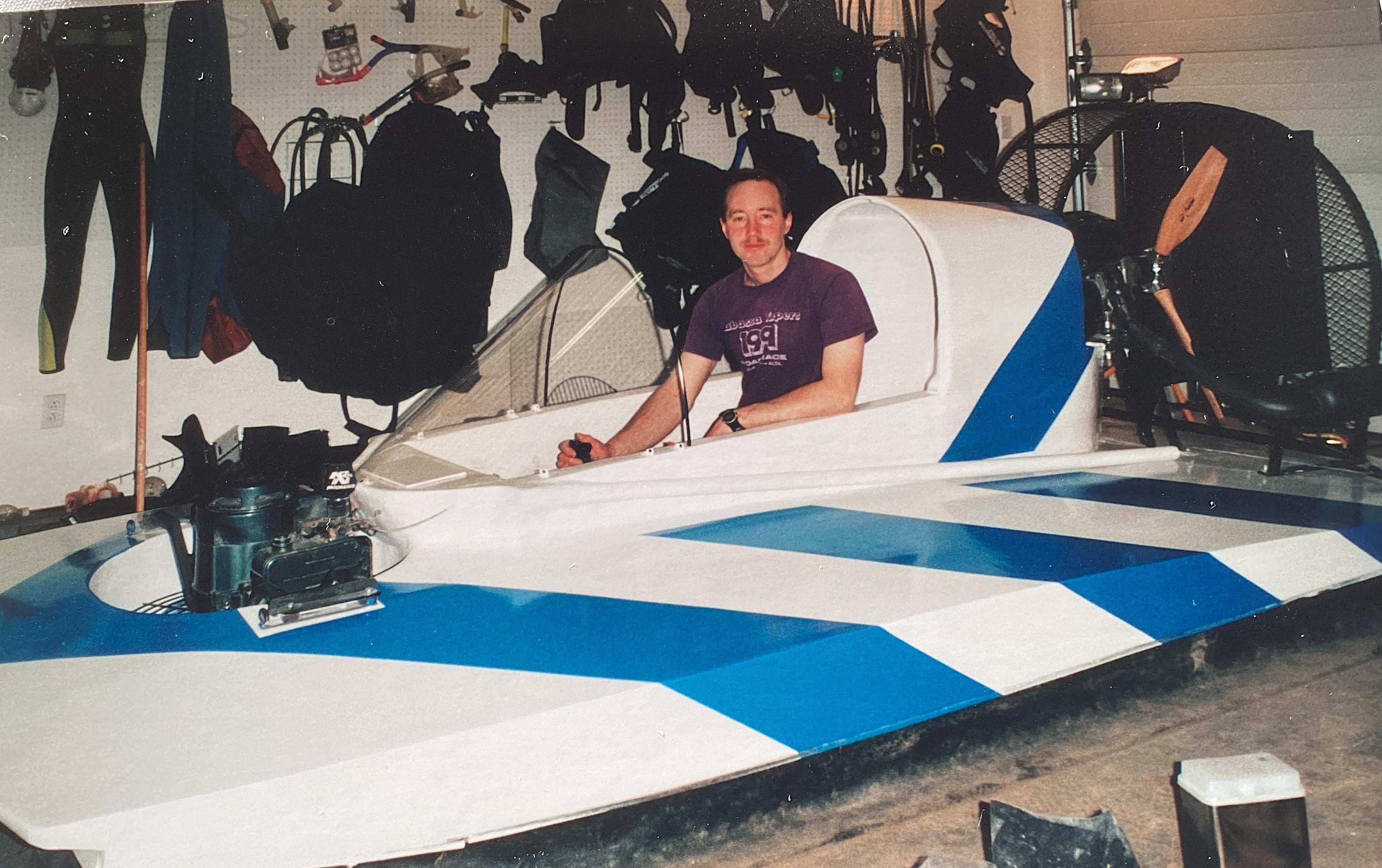 un homme assis dans un aéroglisseur blanc et bleu