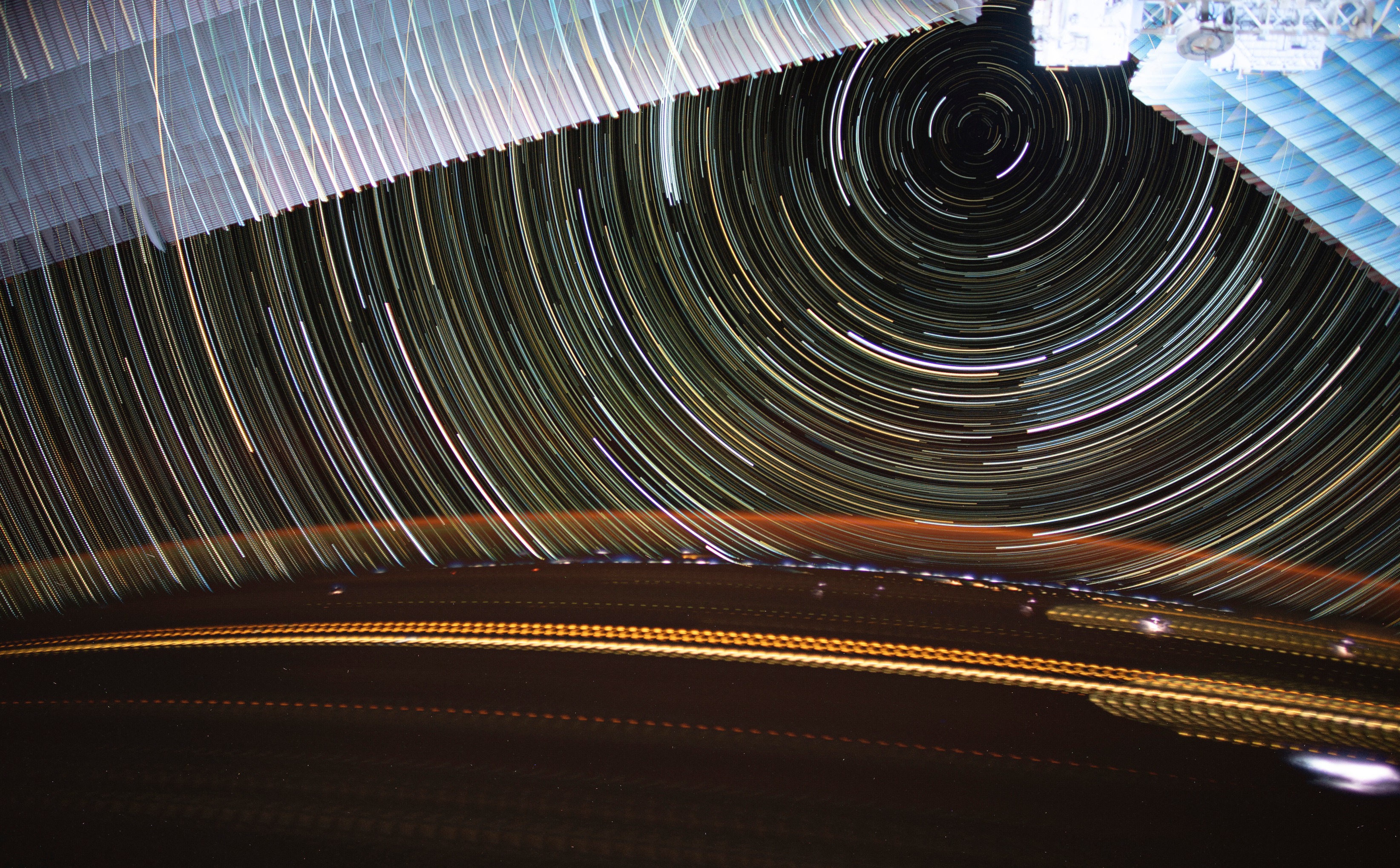 science Des traînées lumineuses traversent la Terre tandis que des étoiles filantes circulent au-dessus dans cette magnifique photo en longue exposition prise par l'astronaute de la NASA, Christina Koch, depuis la Station Spatiale Internationale. En haut de l'image, on peut voir les panneaux solaires de la station spatiale. En bas, des éclairs illuminent la surface terrestre, tandis qu'une lueur orange éclaire l'atmosphère.