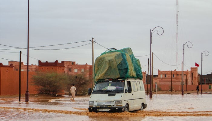 actualités Une voiture traverse une rue inondée après les <a href=