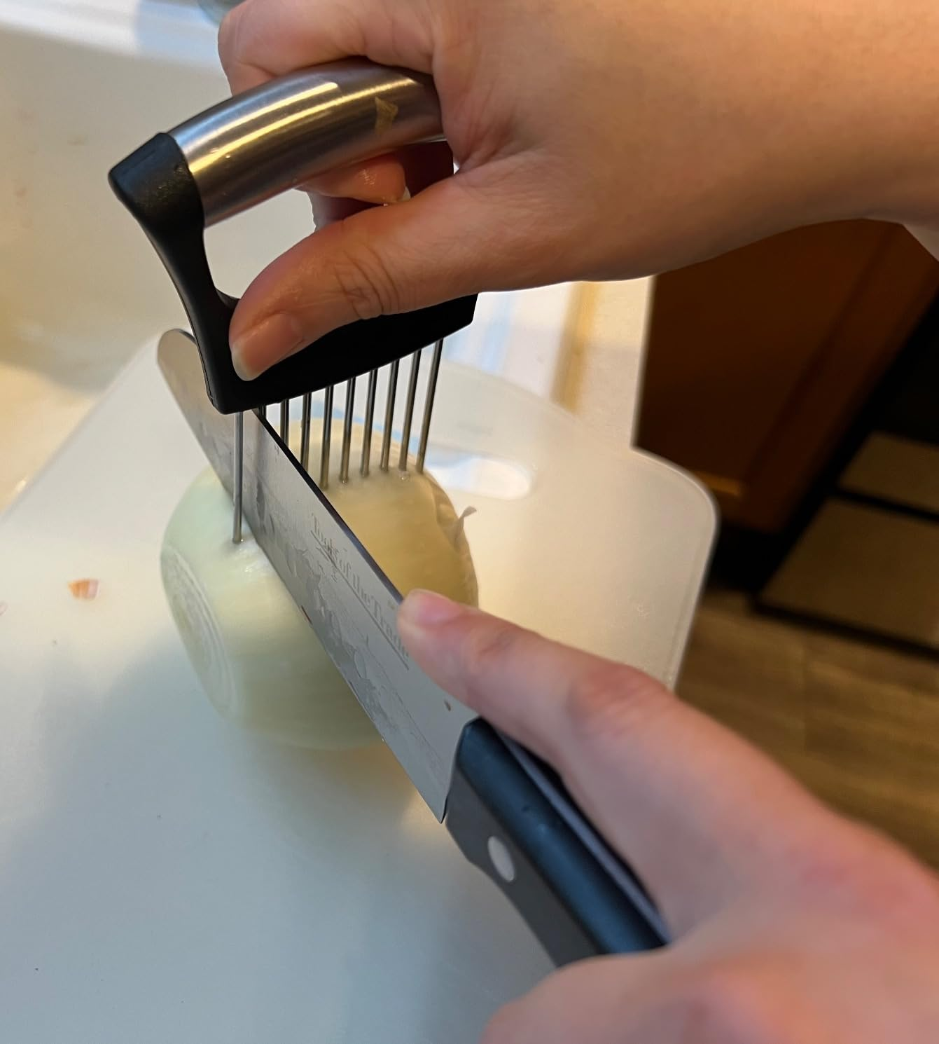 Personne coupant un oignon avec un support à oignons