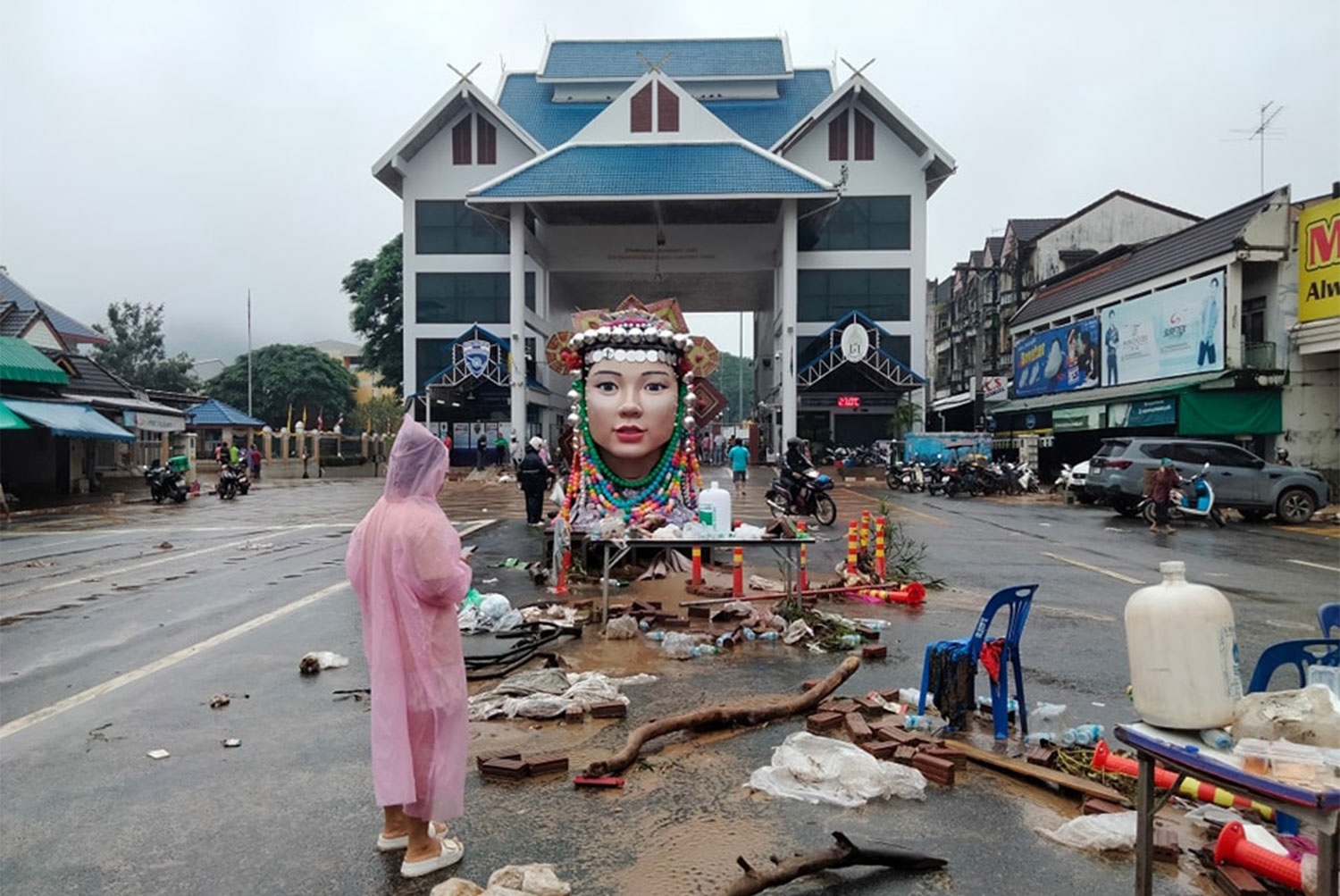 actualité Une femme inspecte les débris emportés sur la route par les inondations après le retrait de l'eau devant le point de contrôle frontalier de Mae Sai dans le district de Mae Sai de Chiang Rai jeudi. (Photo : Hug Mae Sai Facebook)