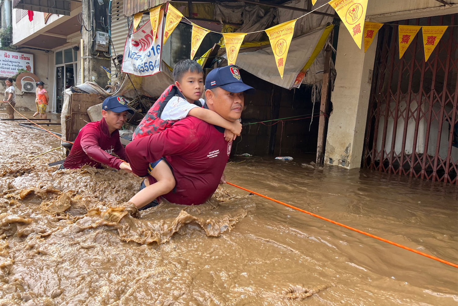 actualité Un policier maritime porte un garçon à travers des eaux profondes dans le district de Mae Sai de la province de Chiang Rai jeudi. (Photo fournie/Wassayos Ngamkham)