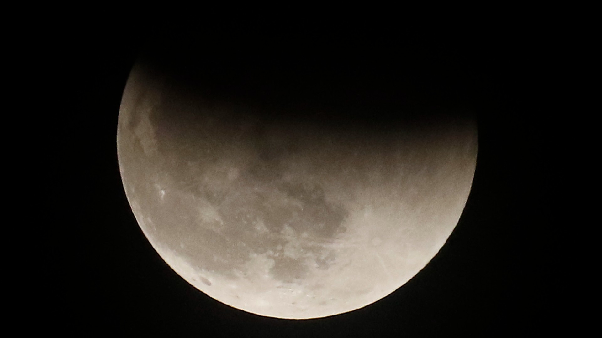 science la lune dans un ciel sombre. le bord supérieur de la lune assombri par une ombre