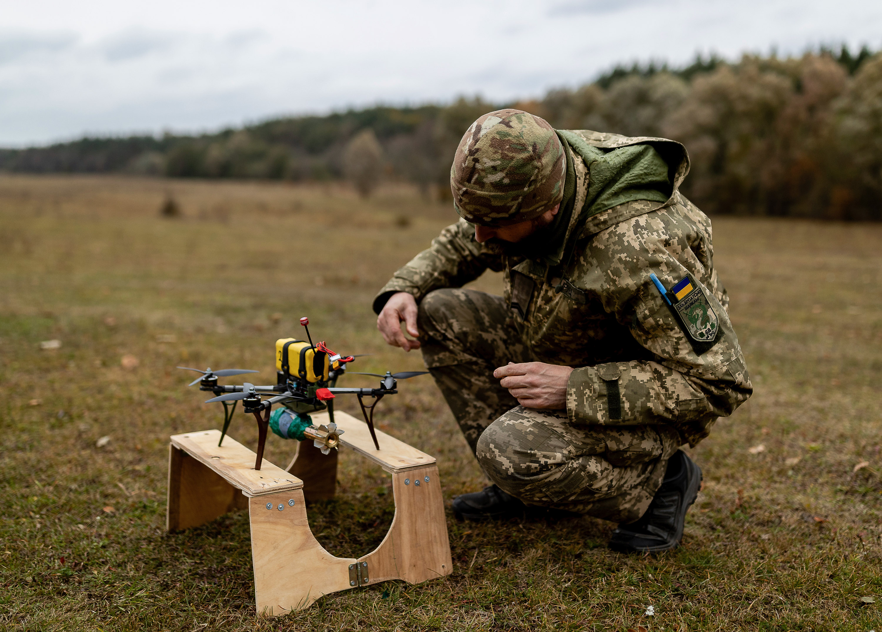 Un soldat ukrainien prépare un drone FPV équipé de munitions factices pour une opération de vol simulée.