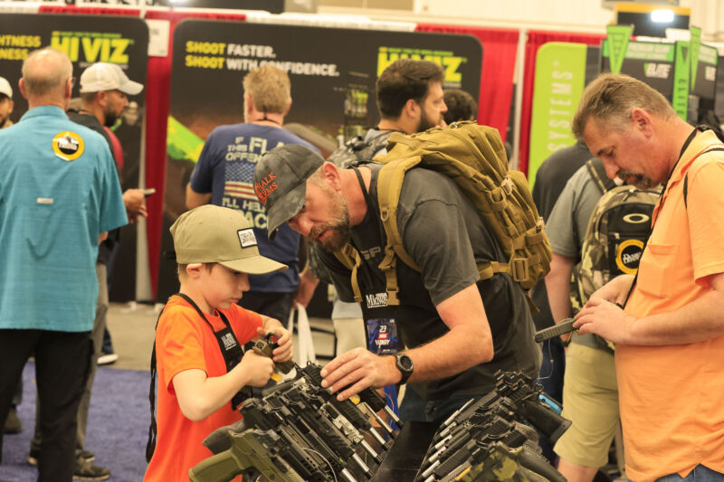 technologie Un homme aide un garçon à examiner une arme à feu lors des réunions annuelles de la National Rifle Association au Center de convention d'Indiana à indianapolis, le 16 avril 2023.