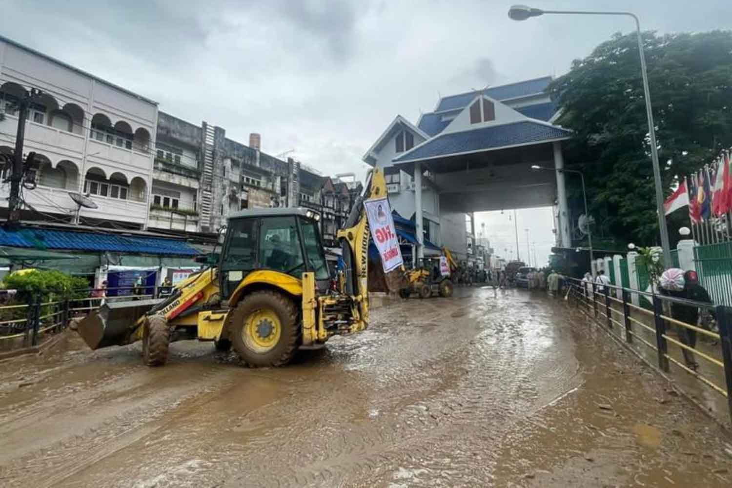 Nettoyage massif : Des tracteurs nettoient une route principale devant le poste frontière de Mae Sai après le retrait des inondations dans le district de Mae Sai à Chiang Rai.