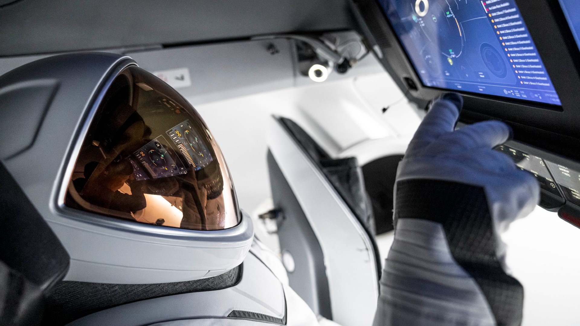 science une personne en combinaison spatiale blanche avec un masque doré touche un écran tactile à l'intérieur d'un cockpit de vaisseau spatial blanc