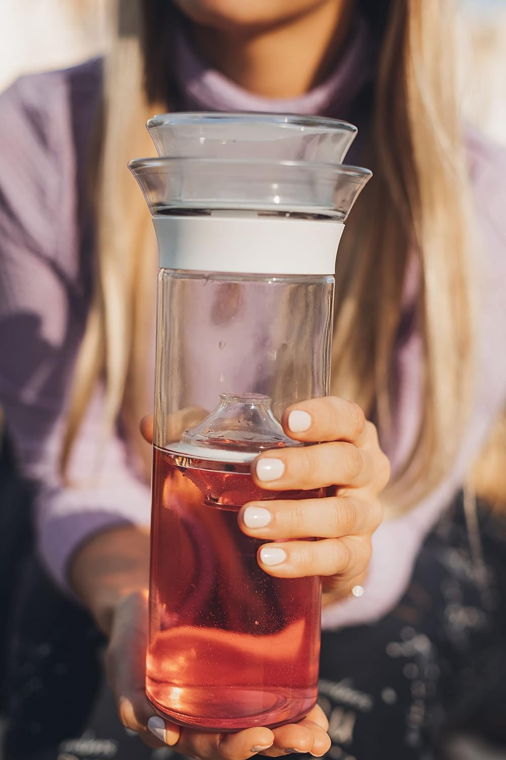 personne tenant une carafe à vin avec un design unique